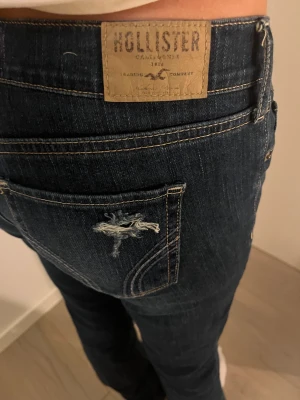 Jeans bootcut low waist  - Säljer dessa skit snygga hollister jeans. Mörkblå med hål i. Fickorna har en fin sömm. Direkt pris 500 !  