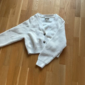 Vit stickad tröja från Monki  - En vit tröja med knappar från monki, bra skick. Storlek XS 