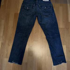 Snygga True Religon Jeans som inte kommer till användning. Inga flaws eller hål. Skick 9/10. Skriv privat om du har frågor om dem eller om fler bilder önskas. Dem är klippta så ytterbensmåttet är 98cm. 
