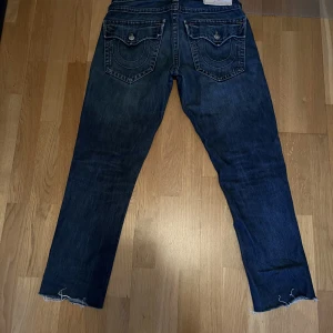 True Religion Jeans 👖  - Snygga True Religon Jeans som inte kommer till användning. Inga flaws eller hål. Skick 9/10. Skriv privat om du har frågor om dem eller om fler bilder önskas. Dem är klippta så ytterbensmåttet är 98cm. 