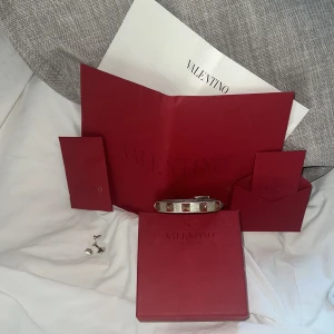 unikt valentino garavani armband - unikt valentino gravani armband med ikonisk silvrig färg med guldnitar. - säljer då det tyvärr inte kommer till mycket användning. - og pris: 2805 allt og tillbehör tillkommer vid köp (dustbag, extra nitar etc) - detta visas i annonsen! skriv vid frågor!