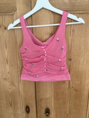 Sött linne med broderade blommor - Jätte fint croptop linne med broderade blommor med söt rosett.