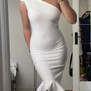 Klänning  - Säljer en vit oanvända studentklänning 