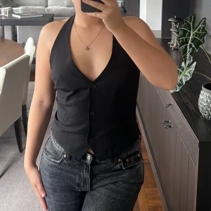 Kostymväst  - Säljer min snygga kostymväst då jag inte får någon användning av den längre. Det är halterneck och halvt öppen rygg. Tre knappar framtill. Perfekt till fest!🪩💅🏼