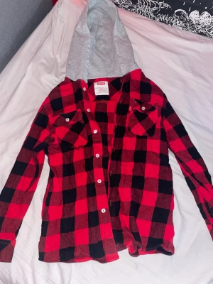 Levi’s flanellskjorta  - En röd/svart flanell skjorta från Levi’s. Använt en del men inte supermycket, skjortan är i mycket bra skick