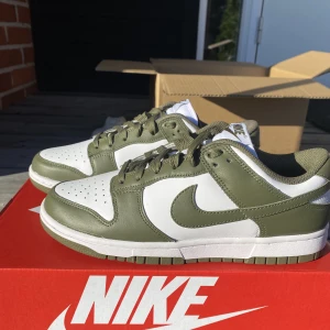 Nike dunk low medium olive - Säljer ett par helt nya Nike dunk low. Köpte precis 2 storlekar och hann inte lämna tillbaka det ena paret i tid. Har kvitto, box och allt. Köpta på soleplus. Nypris 3099 kronor. Priset är inte hugget i sten! Hör av er vid frågor/intresse.