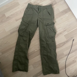 Gröna Cargos - Lågmidjade Mörkgröna Cargobyxor från H&M som knappt använts och inga defekter, säljer för att de inte längre är min stil. Nypris 250 kr