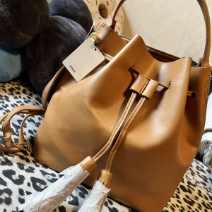 Superfin dam väska från Mango - Superfin dam väska från Mango, med etikett kvar.  Ej använd.  Färg ljus brun/beige  Axelrem finns