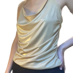 Guldig topp - Superfestligt guldigt linne med öppen rygg! Säljer då det jag aldrig använt det. Passar S-M. Köpt vintage❤️