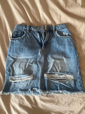 Jeanskjol  - Jeanskjol från NA-KD i storlek 32. Använd fåtal gånger. Säljer då den inte kommer till användning 