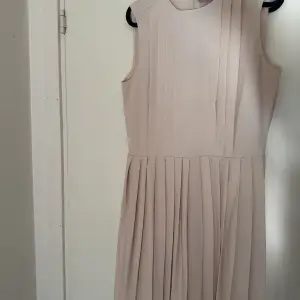 Beige klänning från H&M helt oanvänd. Lårkort