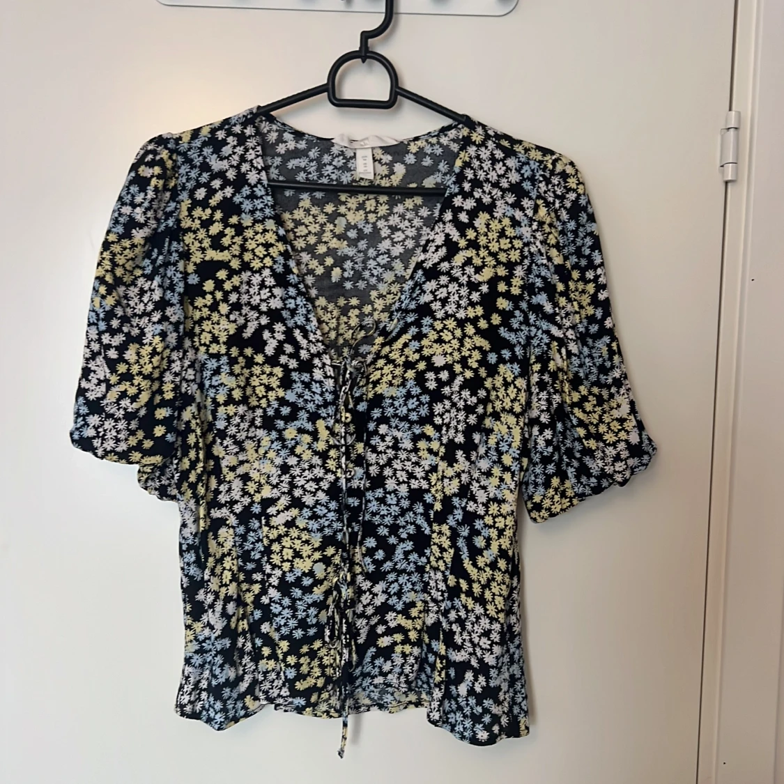 Svart topp med blommigt mönster i blått och gult i viskos