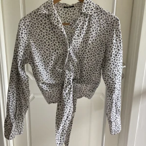 Knytblus - Knytblus med små fina blommor. Vit, svart. Från HM stl s. Fint skick! 🌸