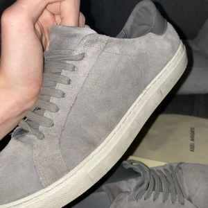 Axel Arigato skor - Säljer mina Axel arigatos i grå färg som jag köpte förra sommaren. Dem är i 7/10 condition och endast sulan som det är lite fel på. Dustbag och skolåda medkommer.