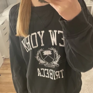Svart college-tröja med tryck💕 -  En svart jättefin tjocktröja ifrån hm som jag har ägt i runt 1 år, kan inte se några fläckar eller liknande. Säljer den då den inte andvänds längre🫶