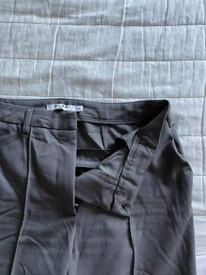 Snygga grå kostymbyxor från NA-KD, byxorna har slits både på in och utsidan vilken blir en snygg detalj 