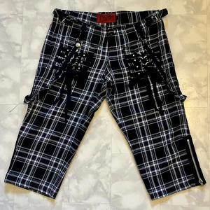 Rutiga kortbyxor/knäbyxor - Häftiga rutiga kortbyxor/knäbyxor med spännen. Från Tripp NYC. Storlek 7 (US), dvs ungefär 36-38 (EU). 