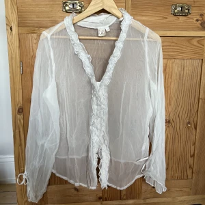 Vit transparent blus - Superfin blus! Har lite skavanker som syns på bilderna. Inget som syns på. Fläcken går säkerligen att få bort.