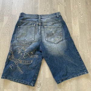 Baggy jorts - Coola jorts med brodering på baksidan.   Storlekar: 40 cm waist 60 cm längd 30 cm thigh/benöppning