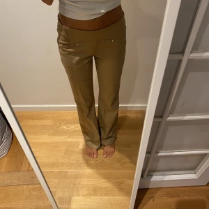 Lågmidjad byxa - Jag säljer dessa helt oanvända byxor från tiger mist. Dem är i en mörkare beige färg och är i storlek XS.