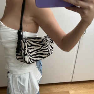 Väska  - Säljer en zebramönstrad väska från Gina tricot. Fint skick, skriv vid frågor eller fler bilder 