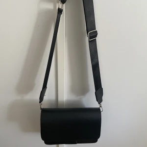 Svart handväska - En enkel, svart handväska som inte har används.