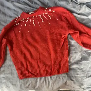 Röd mjuk tröja med vita pärlor
