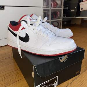 Ett par Jordan 1 low White/gym red-black storlek 42 skick: 9/10  Använd 1 gång utomhus sedan dess har skorna legat i lådan.  900kr