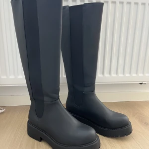 Stövlar - Svarta knähöga stövlar. Oanvända från Monki. Nypris 600kr