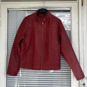 RÖD LÄDERJACKA (faux) - Röd läderjacka (ej äkta, vegansk läder) i superfint skick säljes! Inga skavanker eller dylikt, strl: L men upplever den som en S/M. Vid frågor tveka inte att skicka iväg ett meddelande:)