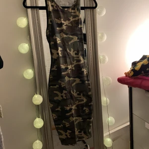 Klänning med kamouflage mösnter - En super skön klänning i stretch material, är inte genomskinlig alls och super skön passform. Är ganska lång då den täcker från nyckelben till strax över knäna. Och super cool detalj med utklippt i ryggen.