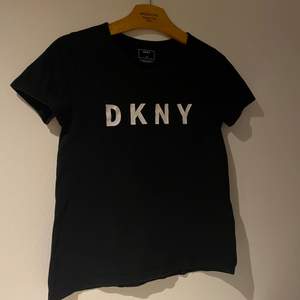 En svart t-shirt i storlek XXS (funkar även som XS) som köptes i en av DKNY’s butiker för några år sedan. Tröjan består av 100% bomull och är väldigt fin i kvaliten. Tecken på användning finns dock (se bild 2 & 3) då det finns lite sprickor i texten - därav priset. Skriv gärna för fler bilder <3