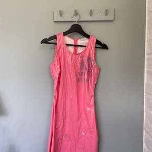 Rosa Lackklänning - Rosa lackklänning. Tyvärr med fläckar från andra lackbyxor. Går säkert att ta bort men har inte testat. Perfekt till temafest. Väldigt snyggpassform.