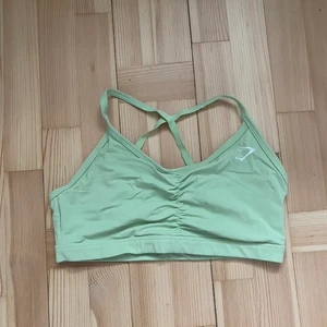 Gymshark sport bh - Limegrön sportbh med ”rynkor” framme och lite mesh i bak. Storlek L men lite liten i storleken