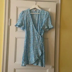 Blå somrig klänning/playsuit - Jätte fin ljus blå blommig klänning/playsuit från topshop men köpt på ASOS. Ser ut som en klänning på men har shorts i. Jätte fin passform kommer bara aldrig till användning! I nyskick, använt 2-3 gånger max. Köpt för 390kr! Frakt tillkommer :))