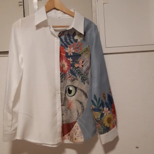 Skjorta L - Skjorta med kattmotiv i storlek L polyester med linnestruktur. Alldrig använd var för stor.