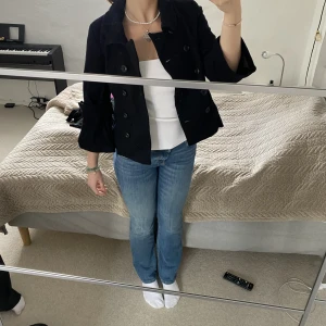 Svart kort kappa - Säljer denna trendiga assnygga kappa från Saint Tropez, där ärmarna är lite kortare och breda!!! Den har inga tydliga tecken på användning. Modellen är 172cm😊😊t