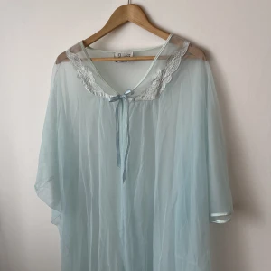 Ljusblå neglige, vintage  - Vintage blå neglige i blått och i fint skick. Söta detaljer och knytes med rosett i fram.  Passar en XS-L, men ger gärna mått! 