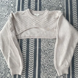 Croppad stickad tröja  - Långärmad stickads croptop som slutar över bröstet. Lite noppig på ärmarna