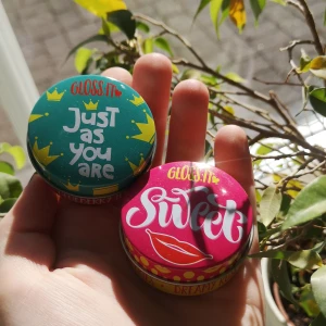 Läppgloss - Två oanvända läpp gloss en blå som ska lukta blåbär och en röd rosa som ska lukta som bär. Det är i små burkar så passar perfekt att ha med sig i fickan eller i en liten väska✨styck pris, skriv helst innan ni köper 