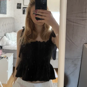 Svart topp - En svart söt topp med rubbat material och volang. Sista bilden syns materialet mer. Passar allt. 