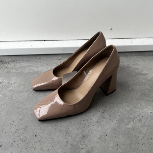 Klackar  - Supersnygg klackar, helt oanvända med prislapp. Puderosa, liten svart fläck (se sista bild). Strl: 40. 