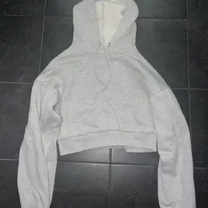 Säljer en grå croppad hoodie från NA-KD i storlek S, pris 200kr. Eller kom med bud