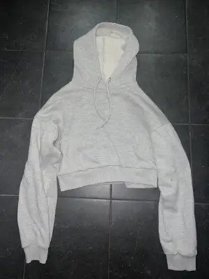 Säljer en grå croppad hoodie från NA-KD i storlek S, pris 200kr. Eller kom med bud