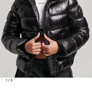 Superdry puffer jacket - Superdry puffer jacket i svart som är slutsåld i typ alla storlekar. Endast använd en halv säsong, i grymt skick. Köpt för 1499kr säljer nu för 1000kr. Storlek 38, har vanligt vis 36 så passar både större o mindre. Glansig. 