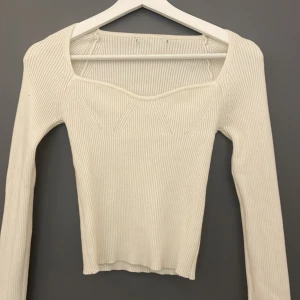 Kräm vit ribbad topp/ tröja - En snygg och populär topp, den är ribbad och har som mönster där fram. Långärmad, suuuper kvalite, aldrig använd. Den kommer inte till användning så säljer den nu. En storlek XS som är väldigt sann i storleken, skit snygg och matcha passar till allt😍