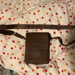 ARMANI VÄSKA  - Säljer nu min Armani väska den är lite andvänd men fortfarande i bra skick lite svåra att få tag på så passa på att köpa den här unika färgen priset kan diskuteras. Påse med följer