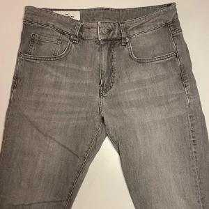Grå Jeans, J.Lindberg - Gråa jeans. Märke J.Lindberg. Modell JAY MID-RISE / SLIM FIT. Storlek W30 L32