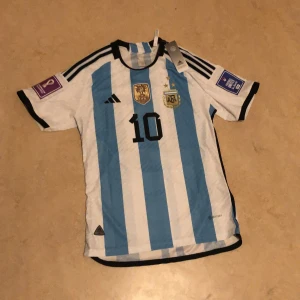 Argentina vm 2022 - Säljer en helt ny Argentina player version vm 2022 tröja för den va för liten. Det står XL fast passar L och även M. Eftersom player version sitter tight på kroppen. Vid fler frågor elr bilder de ba o skriva! 550kr o jag står för frakt