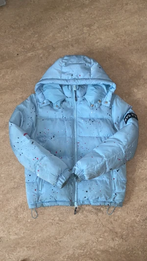 NVLTY Puffer Jacket - En ljusblå nvlty london puffer jacka. Har kemtvättats och är som ny. Använde den i 2 månader bara. Den passar både M och S även om den är i S. Den är lite stor.Den går för runt 1500 på deras hemsida men efter tull blir det runt 3000 för att det är från UK